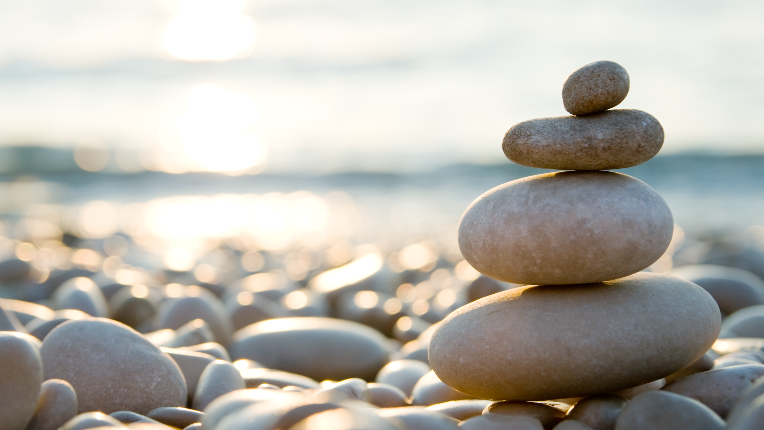 Stones stacked upon one another at a beach on a beautiful sunny day
