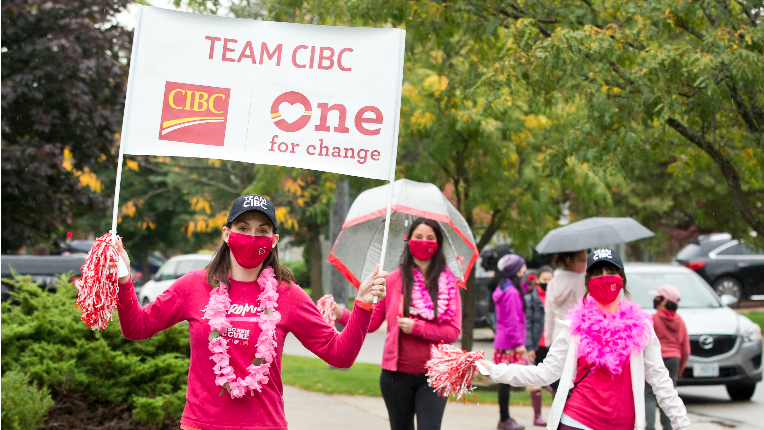 Three females holding a flag that says Team CIBC